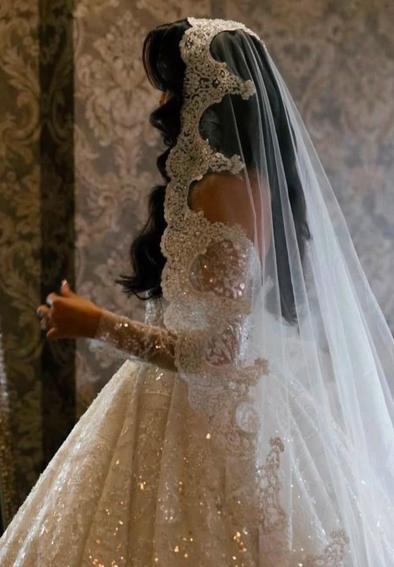 Bride in a lace-edged cathedral veil and a beaded ball gown