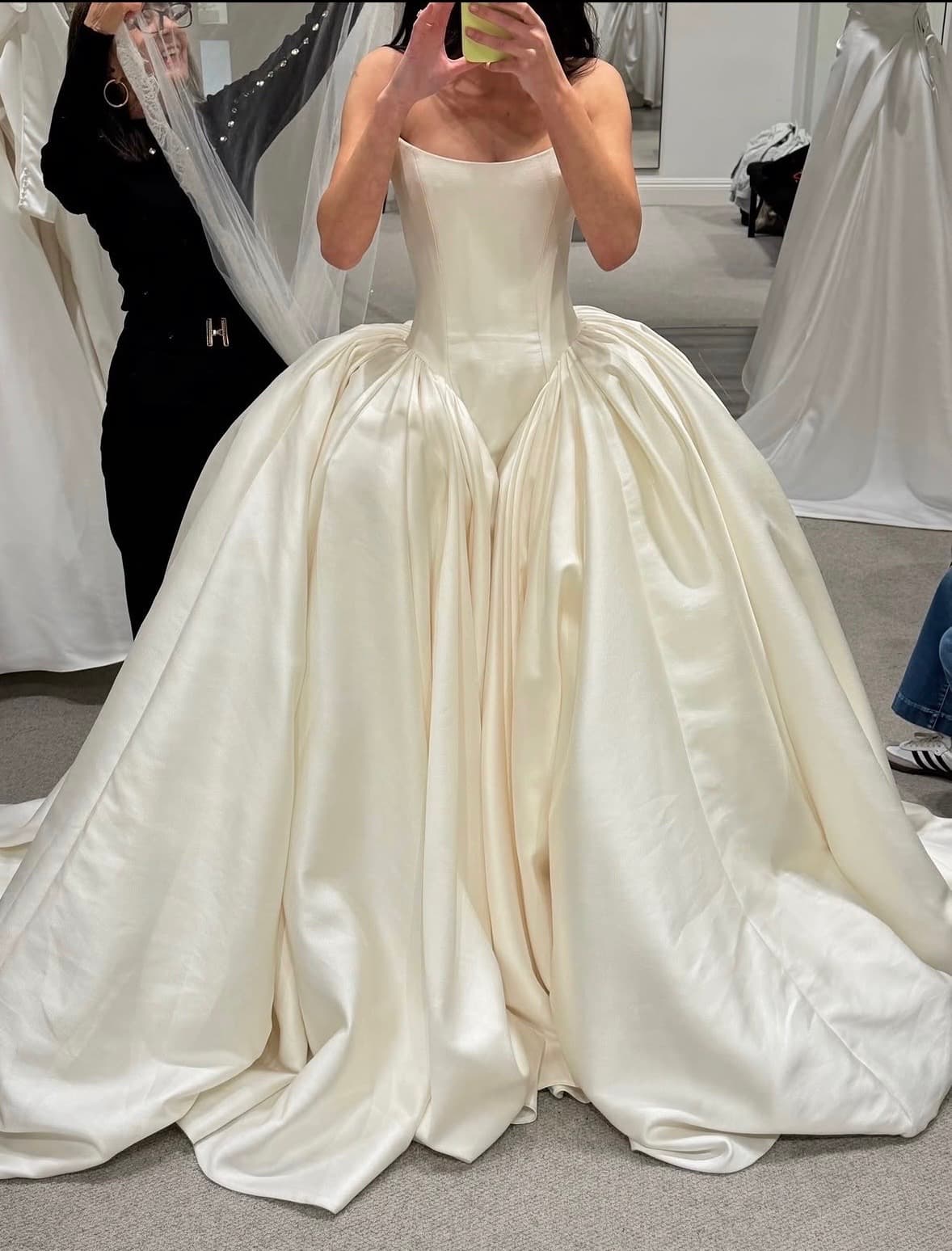 Ivory satin ball gown with a structured strapless bodice at a fitting